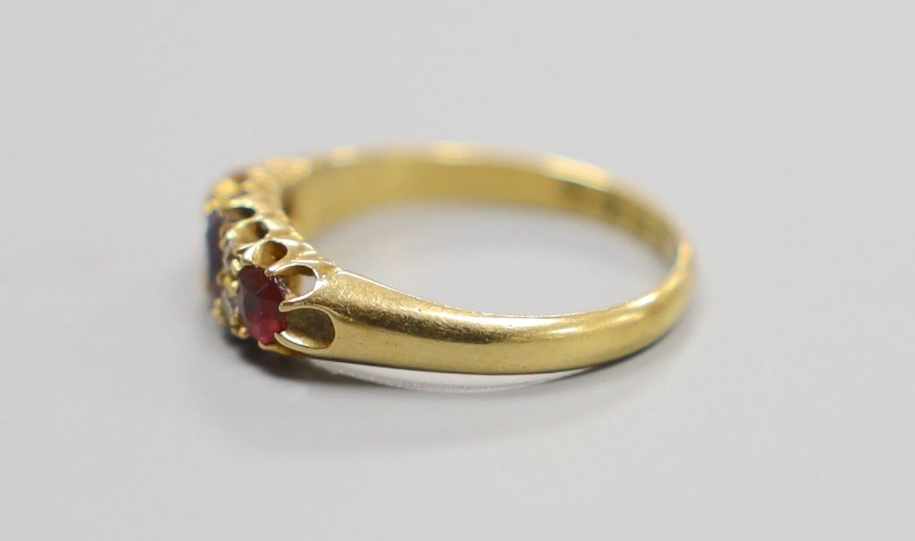 A late Victorian 18ct gold, three stone ruby and four stone diamond set half hoop ring, size M, gross 2.9 grams.